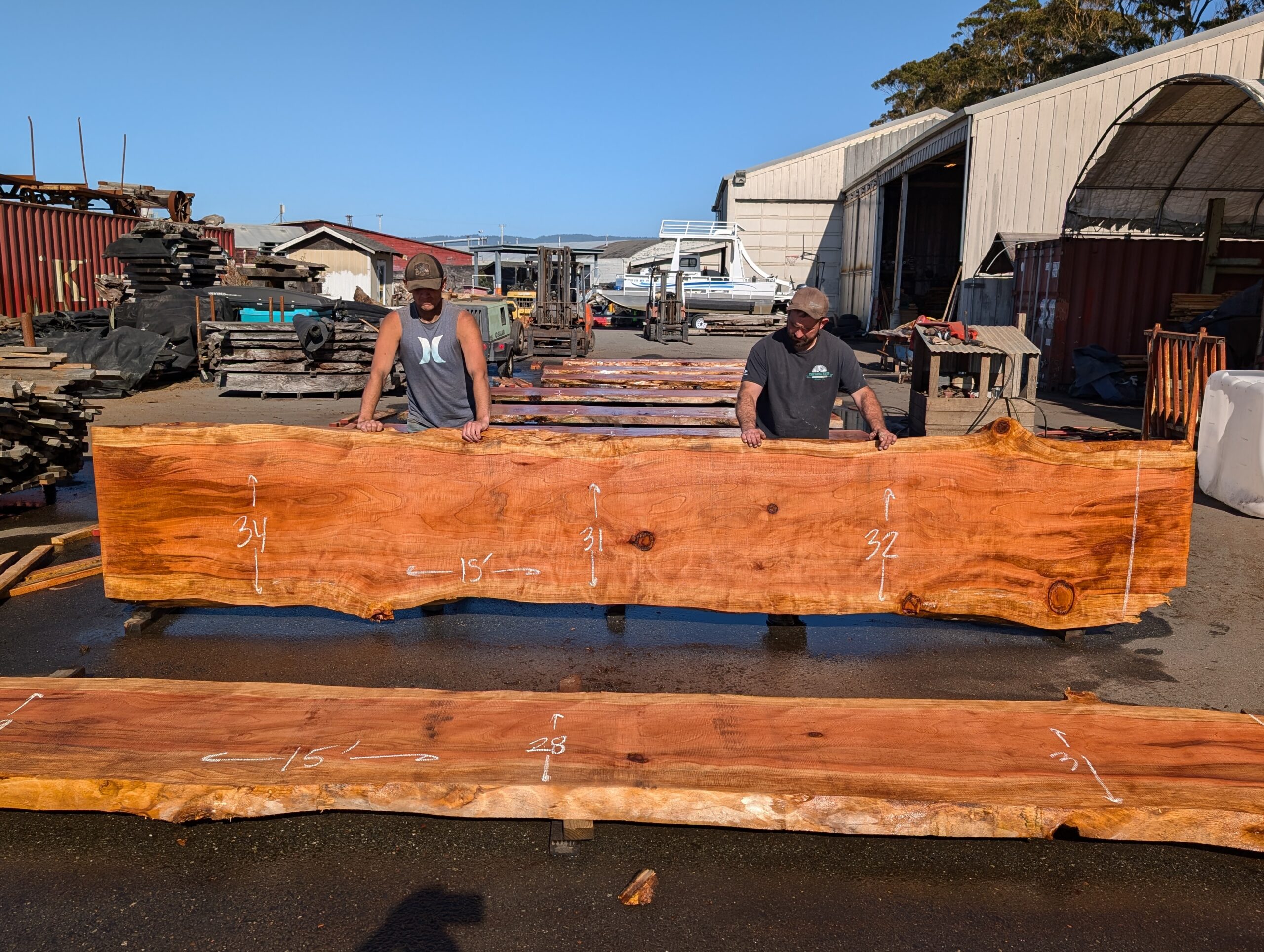 Redwood table top measuring 15 feet long by between 31 and 34 inches wide and 3 inches thick.