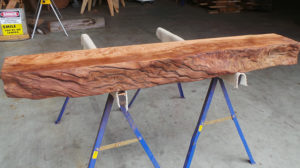 Custom carved rustic wood mantel from ethically salvaged California redwood.