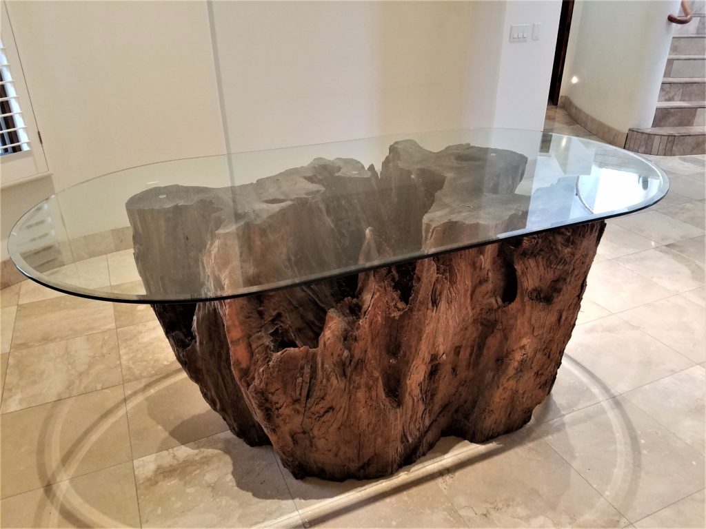 Burl wood furniture - a glass top coffee table with a rustic redwood base